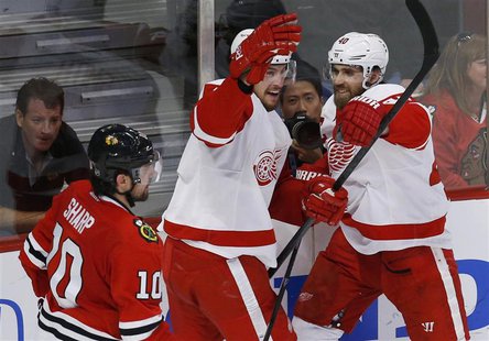 Detroit Red Wings' Brendan Smith (C) celebrates his goal with teammate Henrik Zetterberg as Chicago Blackhawks' Patrick Sharp (L) skates pas Detroit Red Wings' Brendan Smith (C) celebrates his goal with teammate Henrik Zetterberg as Chicago Blackhawks' Patrick Sharp (L) skates pas