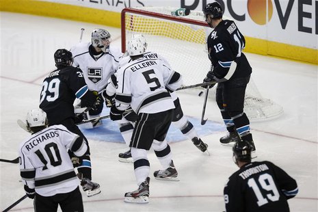 Members of the Los Angeles Kings and San Jose Sharks react as the game-winning puck shot by Sharks' Logan Couture (39) enters the goal in th Members of the Los Angeles Kings and San Jose Sharks react as the game-winning puck shot by Sharks' Logan Couture (39) enters the goal in th