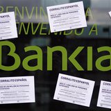 A vandalized Bankia's bank office with papers stuck on it, is seen in Barcelona May 16, 2013. The papers read as "Spanish 'corrallito' of La