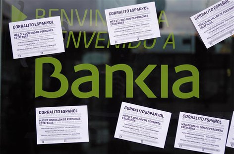 A vandalized Bankia's bank office with papers stuck on it, is seen in Barcelona May 16, 2013. The papers read as "Spanish 'corrallito' of La A vandalized Bankia's bank office with papers stuck on it, is seen in Barcelona May 16, 2013. The papers read as "Spanish 'corrallito' of La