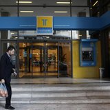 A man walks outside of the Hellenic Postbank's headquarters in Athens January 4, 2013. REUTERS/John Kolesidis A man walks outside of the Hellenic Postbank's headquarters in Athens January 4, 2013. REUTERS/John Kolesidis