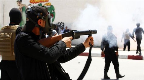 A police officer fires tear gas to break up a protest in the city of Kairouan May 19, 2013. REUTERS/Zoubeir Souissi A police officer fires tear gas to break up a protest in the city of Kairouan May 19, 2013. REUTERS/Zoubeir Souissi