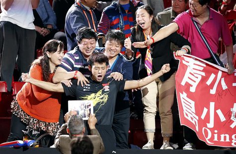 China's Zhang Jike (C) reacts among family members after defeating his compatriot Wang Hao in the men's singles final at the World Team Tabl China's Zhang Jike (C) reacts among family members after defeating his compatriot Wang Hao in the men's singles final at the World Team Tabl