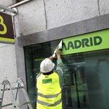 A worker removes a Caja Madrid signage to replace it with Bankia logos at a Bankia branch in Madrid May 20, 2013. REUTERS/Paul Hanna A worker removes a Caja Madrid signage to replace it with Bankia logos at a Bankia branch in Madrid May 20, 2013. REUTERS/Paul Hanna