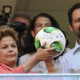 Brazil's President Dilma Rousseff (L) shows her autograph on a soccer ball as she stands beside Brasilia's Governor Agnelo Queiroz (R) durin Brazil's President Dilma Rousseff (L) shows her autograph on a soccer ball as she stands beside Brasilia's Governor Agnelo Queiroz (R) durin