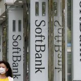 A woman walks past logos of Softbank Corp at its branch in Tokyo April 17, 2013. REUTERS/Yuya Shino A woman walks past logos of Softbank Corp at its branch in Tokyo April 17, 2013. REUTERS/Yuya Shino