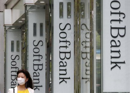 A woman walks past logos of Softbank Corp at its branch in Tokyo April 17, 2013. REUTERS/Yuya Shino A woman walks past logos of Softbank Corp at its branch in Tokyo April 17, 2013. REUTERS/Yuya Shino