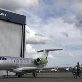 A worker rides a bicycle around the hangars next to a private jet at the Embraer headquarters in Sao Jose dos Campos, 100 km (62 miles) from A worker rides a bicycle around the hangars next to a private jet at the Embraer headquarters in Sao Jose dos Campos, 100 km (62 miles) from