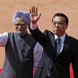 Chinese Premier Li Keqiang (R) and India's Prime Minister Manmohan Singh wave towards the media during Li's ceremonial reception at the fore
