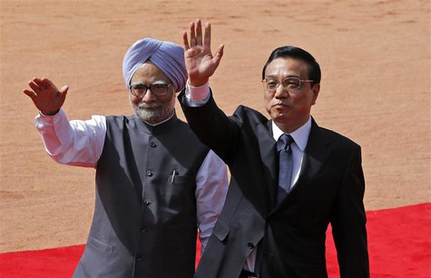 Chinese Premier Li Keqiang (R) and India's Prime Minister Manmohan Singh wave towards the media during Li's ceremonial reception at the fore Chinese Premier Li Keqiang (R) and India's Prime Minister Manmohan Singh wave towards the media during Li's ceremonial reception at the fore