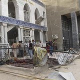 Onlookers gather outside Zain al-Abideen mosque, a Shiite place of worship, to inspect damage a day after a suicide bomb attack in Hilla, 10
