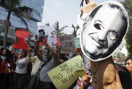 People protest holding masks printed with the face of Mexican telecommunications and retail tycoon Carlos Slim as he attends the Meeting of People protest holding masks printed with the face of Mexican telecommunications and retail tycoon Carlos Slim as he attends the Meeting of