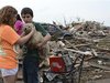 Abby Madi (L) and Peterson Zatterlee comforts Zaterlee's dog Rippy, after a tornado struck Moore, Oklahoma, May 20, 2013. 
REUTERS/Gene Blevins