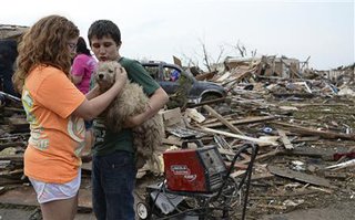Abby Madi (L) and Peterson Zatterlee comforts Zaterlee's dog Rippy, after a tornado struck Moore, Oklahoma, May 20, 2013. 
REUTERS/Gene Blevins