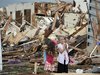 Two girls stand in rubble after a tornado struck Moore, Oklahoma, May 20, 2013. 
REUTERS/Gene Blevins