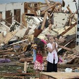Two girls stand in rubble after a tornado struck Moore, Oklahoma, May 20, 2013. REUTERS/Gene Blevins