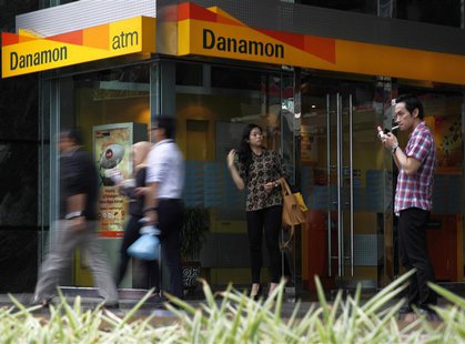 A man smokes a cigarette near a Danamon Bank ATM in Jakarta May 22, 2013. REUTERS/Beawiharta A man smokes a cigarette near a Danamon Bank ATM in Jakarta May 22, 2013. REUTERS/Beawiharta