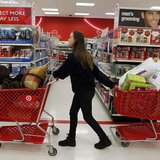 A woman pulls shopping carts through the aisle of a Target store on the shopping day dubbed "Black Friday" in Torrington, Connecticut Novemb