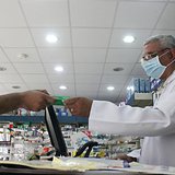 A man, wearing a surgical mask as a precautionary measure against the novel coronavirus, pays for medicine at a hospital pharmacy in Khobar A man, wearing a surgical mask as a precautionary measure against the novel coronavirus, pays for medicine at a hospital pharmacy in Khobar