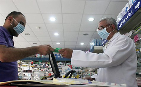 A man, wearing a surgical mask as a precautionary measure against the novel coronavirus, pays for medicine at a hospital pharmacy in Khobar A man, wearing a surgical mask as a precautionary measure against the novel coronavirus, pays for medicine at a hospital pharmacy in Khobar