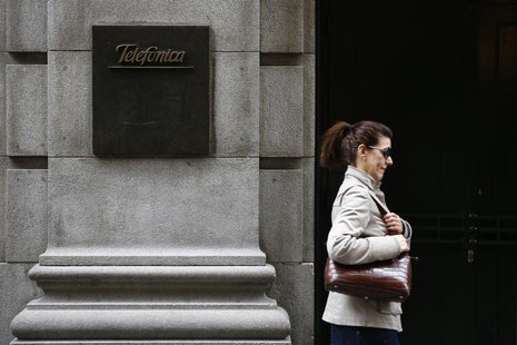 A woman walks past Telefonica's building in central Madrid March 26, 2013. REUTERS/Juan Medina A woman walks past Telefonica's building in central Madrid March 26, 2013. REUTERS/Juan Medina