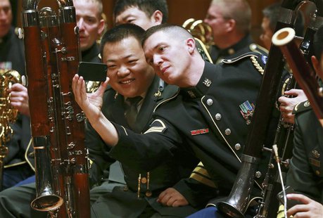 Musicians from the military bands of China's People's Liberation Army and the U.S. Army take photos during a rehearsal for their joint conce Musicians from the military bands of China's People's Liberation Army and the U.S. Army take photos during a rehearsal for their joint conce