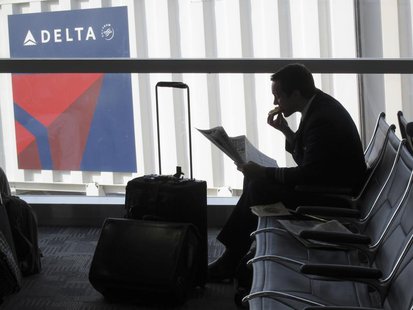 A passenger waits for his flight near a Delta Air Lines logo at Detriot Airport November 20, 2010. REUTERS/Sim Wei Yang A passenger waits for his flight near a Delta Air Lines logo at Detriot Airport November 20, 2010. REUTERS/Sim Wei Yang