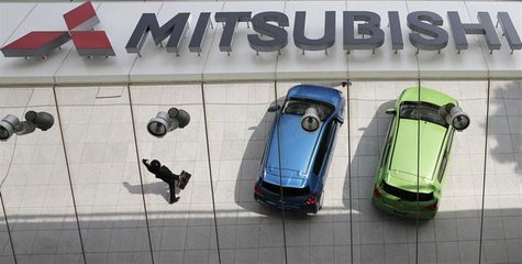 Mitsubishi Motors Corp's vehicles and a passer-by are reflected on an external wall at the company headquarters in Tokyo April 25, 2013. REU Mitsubishi Motors Corp's vehicles and a passer-by are reflected on an external wall at the company headquarters in Tokyo April 25, 2013. REU