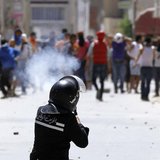 A riot police officer fires teargas during clashes with supporters of Islamist group Ansar al-Sharia at Hai al Tadamon in Tunis May 19, 2013