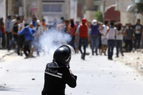 A riot police officer fires teargas during clashes with supporters of Islamist group Ansar al-Sharia at Hai al Tadamon in Tunis May 19, 2013 A riot police officer fires teargas during clashes with supporters of Islamist group Ansar al-Sharia at Hai al Tadamon in Tunis May 19, 2013