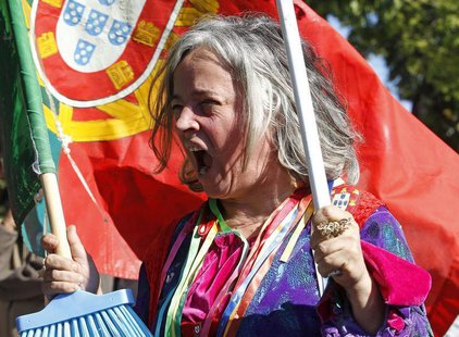 A woman with a Portuguese flag shouts slogans during a protest against austerity in front of the presidential palace in Lisbon May 20, 2013. A woman with a Portuguese flag shouts slogans during a protest against austerity in front of the presidential palace in Lisbon May 20, 2013.