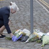 A woman places flowers outside the Royal Military Barracks, near the scene where a British soldier was killed in Woolwich, southeast London A woman places flowers outside the Royal Military Barracks, near the scene where a British soldier was killed in Woolwich, southeast London