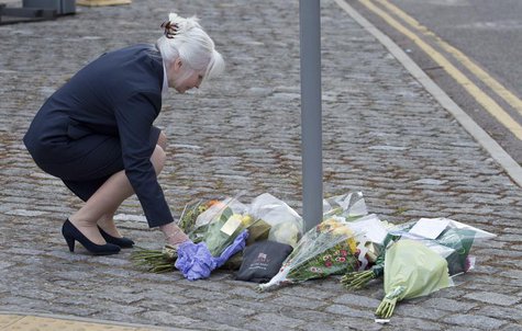 A woman places flowers outside the Royal Military Barracks, near the scene where a British soldier was killed in Woolwich, southeast London A woman places flowers outside the Royal Military Barracks, near the scene where a British soldier was killed in Woolwich, southeast London