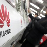 A man looks at a Huawei mobile phone as he shops at an electronic market in Shanghai January 22, 2013. REUTERS/Carlos Barria