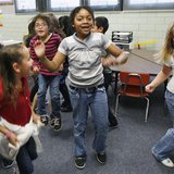 Students at Rose Hill Elementary School jump around doing a counting exercise that is also aerobic exercise in their classroom in Commerce C