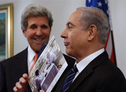 Israeli Prime Minster Benjamin Netanyahu (R) shows a present given to him by U.S. Secretary of State John Kerry in Jerusalem May 23, 2013. R Israeli Prime Minster Benjamin Netanyahu (R) shows a present given to him by U.S. Secretary of State John Kerry in Jerusalem May 23, 2013. R