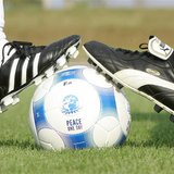 Players wearing Puma and an Adidas soccer shoes pose before a friendly soccer match between German sports goods firm Puma and German sportin