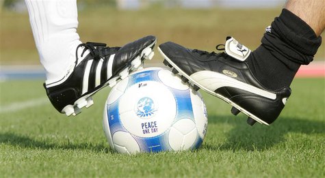 Players wearing Puma and an Adidas soccer shoes pose before a friendly soccer match between German sports goods firm Puma and German sportin Players wearing Puma and an Adidas soccer shoes pose before a friendly soccer match between German sports goods firm Puma and German sportin