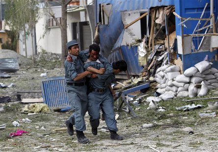 A wounded Afghan policeman (C) is helped away from the site of an explosion in Kabul May 24, 2013. REUTERS/Omar Sobhani A wounded Afghan policeman (C) is helped away from the site of an explosion in Kabul May 24, 2013. REUTERS/Omar Sobhani