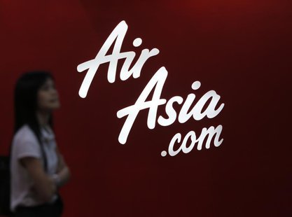 A customer reads an advertisement outside an AirAsia ticketing office in Kuala Lumpur August 29, 2012. REUTERS/Bazuki Muhammad A customer reads an advertisement outside an AirAsia ticketing office in Kuala Lumpur August 29, 2012. REUTERS/Bazuki Muhammad