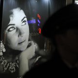 A security guard walks past an image of Elizabeth Taylor outside Christie's auction house during an auction of the late actress' jewelry, cl A security guard walks past an image of Elizabeth Taylor outside Christie's auction house during an auction of the late actress' jewelry, cl