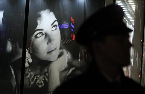 A security guard walks past an image of Elizabeth Taylor outside Christie's auction house during an auction of the late actress' jewelry, cl A security guard walks past an image of Elizabeth Taylor outside Christie's auction house during an auction of the late actress' jewelry, cl