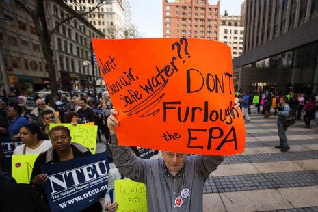 A federal employee holds up a sign protesting the effects of sequestration and the practice of furloughs at a gathering in New York, May 7, A federal employee holds up a sign protesting the effects of sequestration and the practice of furloughs at a gathering in New York, May 7,