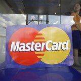 An employee stands behind a MasterCard logo during the launch of the international credit card issuer's first ATM transaction in Myanmar, in