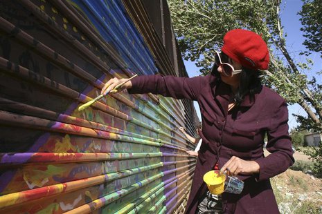 Artist Gretchen Baer paints on a fence marking the U.S. border in Naco, Mexico April 17, 2013. REUTERS/Tim Gaynor Artist Gretchen Baer paints on a fence marking the U.S. border in Naco, Mexico April 17, 2013. REUTERS/Tim Gaynor