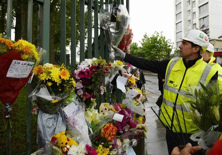 A worker adds flowers to other floral tributes to Drummer Lee Rigby, of the British Army's 2nd Battalion The Royal Regiment of Fusiliers, at A worker adds flowers to other floral tributes to Drummer Lee Rigby, of the British Army's 2nd Battalion The Royal Regiment of Fusiliers, at