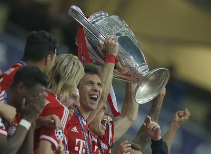 Bayern Munich's Arjen Robben holds the trophy with team mates after defeating Borussia Dortmund in their Champions League Final soccer match Bayern Munich's Arjen Robben holds the trophy with team mates after defeating Borussia Dortmund in their Champions League Final soccer match