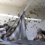 Two men inspect their damage house after two rockets hit their area in a Beirut suburbs May 26, 2013. Two rockets hit a Hezbollah-controlled Two men inspect their damage house after two rockets hit their area in a Beirut suburbs May 26, 2013. Two rockets hit a Hezbollah-controlled