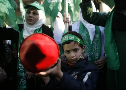 A Palestinian boy poses as he holds a model of rocket during a rally in the West Bank city of Nablus, marking the 25th anniversary of the fo A Palestinian boy poses as he holds a model of rocket during a rally in the West Bank city of Nablus, marking the 25th anniversary of the fo