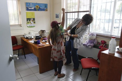 A pediatrician examines a girl inside a social medical centre in the Helliniko suburb of Athens May 24, 2012. REUTERS/Yorgos Karahalis A pediatrician examines a girl inside a social medical centre in the Helliniko suburb of Athens May 24, 2012. REUTERS/Yorgos Karahalis